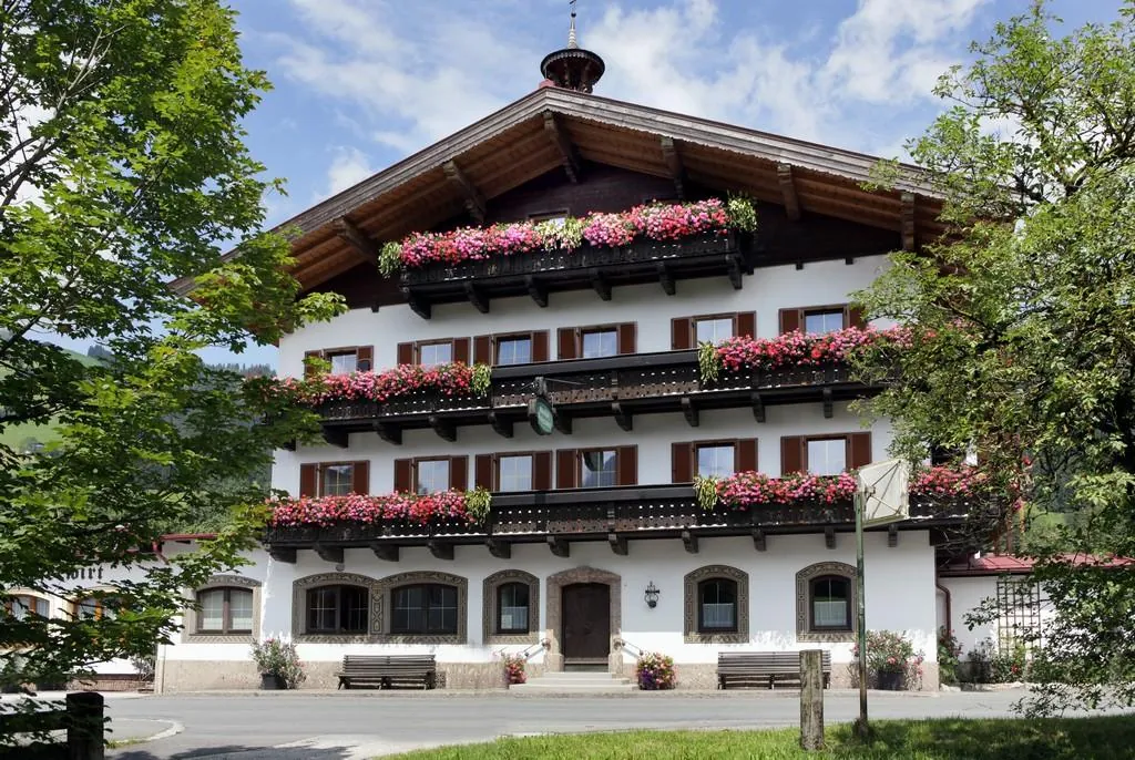 Pension Hoferwirt im Sommer mit Blumen an den Balkonen